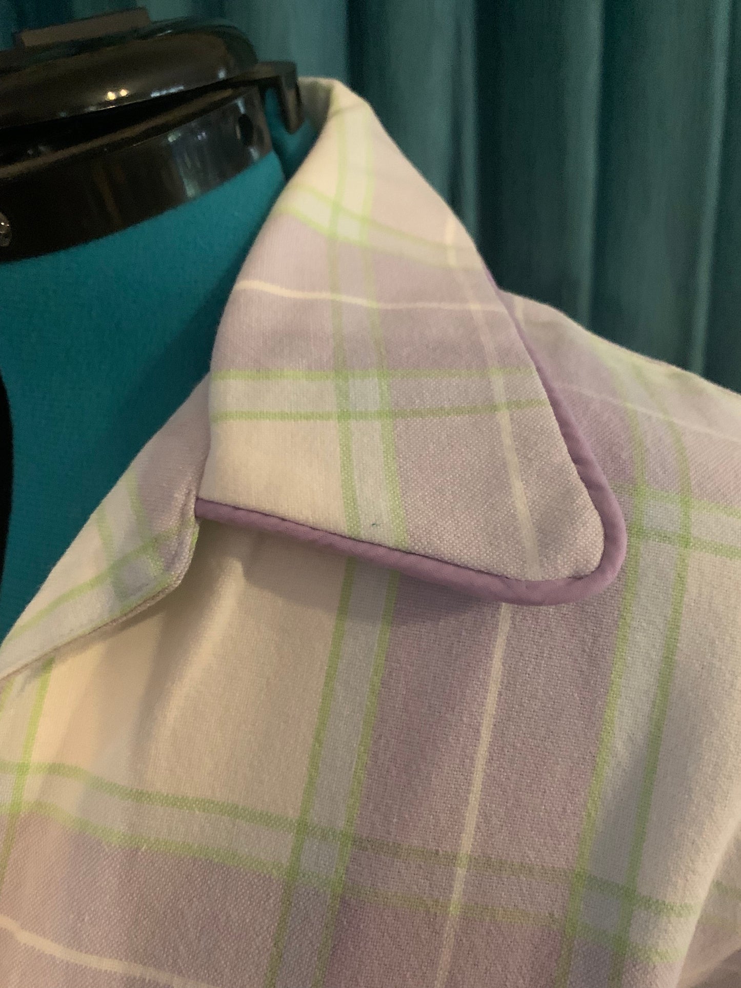 "Close-up of the Light Mauve Cotton Shirt collar on a dress form, showing the soft lilac and cream windowpane check cotton fabric with mauve contrast piping trim detail"